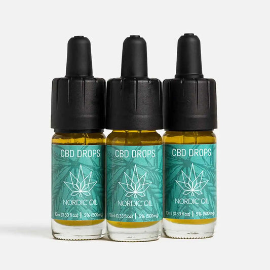 Três frascos de CBD drops da Nordic Oil com rótulos verde-azulado e tampas pretas.
