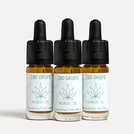 Três frascos de CBD Drops da Nordic Oil com rótulos brancos e logótipo de folha de cânhamo