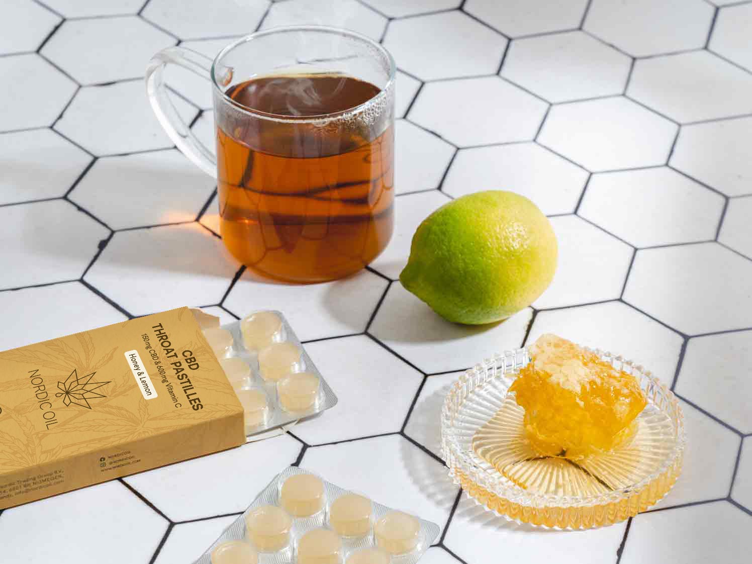 copo de chá ao lado de cápsulas de cbd mel e uma lima